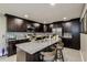 Stylish kitchen featuring dark cabinets, stainless steel appliances, a granite island, and bar stools at 6628 1St N St, St Petersburg, FL 33702