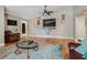 Living room with wood floors, area rug, ceiling fan, and wall-mounted TV at 6628 1St N St, St Petersburg, FL 33702