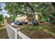 Cars parked in the driveway behind a white picket fence at 6628 1St N St, St Petersburg, FL 33702
