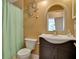 Bathroom with a white vanity, green shower curtain, and arched mirror at 8608 Poinsettia Dr, Temple Terrace, FL 33637