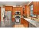 Kitchen with granite countertops, stainless steel appliances, and wood cabinets at 8608 Poinsettia Dr, Temple Terrace, FL 33637