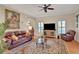 Spacious living room featuring hardwood floors, a fireplace, and comfortable leather furniture at 8608 Poinsettia Dr, Temple Terrace, FL 33637