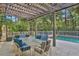 Relaxing pergola covered patio with outdoor furniture and a view of a swimming pool at 8608 Poinsettia Dr, Temple Terrace, FL 33637