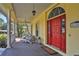 Inviting front porch with white columns, red door, and comfortable seating at 8608 Poinsettia Dr, Temple Terrace, FL 33637