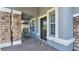 Front porch with stone columns, rocking chairs, and a decorative doormat at 11928 Frost Aster Dr, Riverview, FL 33579