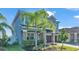 Two-story house with gray siding, palm trees, and a brown garage door at 11928 Frost Aster Dr, Riverview, FL 33579