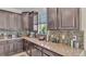 Modern kitchen with granite countertops, dark wood cabinets, and a tile backsplash at 11928 Frost Aster Dr, Riverview, FL 33579