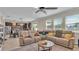 Open living room with sectional sofa and views of the kitchen and backyard at 11928 Frost Aster Dr, Riverview, FL 33579