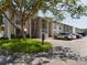 Exterior view of a condo building with parking and landscaping at 2625 State Road 590 # 124, Clearwater, FL 33759