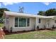 Tan house with a landscaped yard and palm tree at 6702 71St N Ave, Pinellas Park, FL 33781
