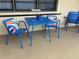 Inviting outdoor patio area with a vibrant blue metal table and chairs at 24 Quails Run Blvd # 3, Englewood, FL 34223