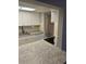 Bright kitchen with white cabinetry, stainless steel sink, and a view of the breakfast bar and adjoining spaces at 24 Quails Run Blvd # 3, Englewood, FL 34223