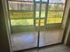 Enclosed patio with sliding glass doors, offering views of the lush, green outdoor space at 24 Quails Run Blvd # 3, Englewood, FL 34223