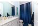 Bathroom with blue shower curtain and white vanity at 5330 Silver Sun Dr, Apollo Beach, FL 33572