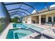 Resort-style pool and spa with covered lanai, outdoor kitchen, and lake view at 5330 Silver Sun Dr, Apollo Beach, FL 33572