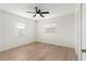 Bright bedroom with wood-look floors, ceiling fan, and two windows at 13065 Via Aurelia, Placida, FL 33946