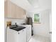 Laundry room with washer, dryer, and overhead cabinets at 13065 Via Aurelia, Placida, FL 33946