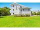 Two-story house with white siding, a large grassy yard, and a porch at 13065 Via Aurelia, Placida, FL 33946