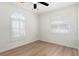 Well-lit bedroom featuring wood-look floors and plantation shutters at 13065 Via Aurelia, Placida, FL 33946