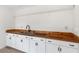 Simple basement kitchen with wood countertop and white cabinets at 13065 Via Aurelia, Placida, FL 33946