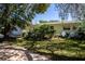 Single story home with white exterior, mature landscaping, and a spacious front yard at 1479 S Evergreen Ave, Clearwater, FL 33756