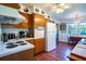 Kitchen with wood cabinets, white appliances, and hardwood floors at 1479 S Evergreen Ave, Clearwater, FL 33756