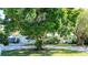 House exterior showcasing a white-painted home with a lush, green lawn and large trees at 1479 S Evergreen Ave, Clearwater, FL 33756