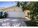White brick home with a two-car garage and a paved driveway at 1479 S Evergreen Ave, Clearwater, FL 33756