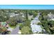 Wide aerial view of the property and surrounding neighborhood, featuring mature trees and a city skyline in the distance at 1479 S Evergreen Ave, Clearwater, FL 33756