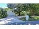 Charming single story home with a white exterior, a large driveway, and mature landscaping at 1479 S Evergreen Ave, Clearwater, FL 33756
