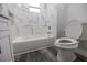 Newly renovated bathroom with a white bathtub and toilet at 2335 W Beach St, Tampa, FL 33607