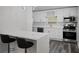 Modern kitchen featuring stainless steel appliances, sleek white cabinets, and a marble countertop breakfast bar at 2335 W Beach St, Tampa, FL 33607