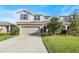 Two-story house with a neutral color scheme, a two-car garage, and a well-manicured lawn at 10662 Hawks Landing Dr, Land O Lakes, FL 34638