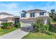 Two-story house with a neutral color scheme, a two-car garage, and a landscaped yard at 10662 Hawks Landing Dr, Land O Lakes, FL 34638