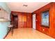 Living room with wood-paneled walls, light flooring, and a kitchen bar at 4116 Haines N Rd, St Petersburg, FL 33703