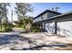 Two-story house with gray siding, double garage, and landscaped yard at 4911 W Juno St, Tampa, FL 33629