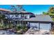 Two-story house with gray siding, double garage, and landscaped yard at 4911 W Juno St, Tampa, FL 33629