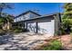 Two-story house with gray siding, double garage, and landscaped yard at 4911 W Juno St, Tampa, FL 33629