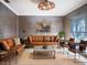 Living room with brown leather sectional and armchairs, a large TV, and a rustic coffee table at 4911 W Juno St, Tampa, FL 33629