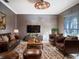 Spacious living room with brown leather furniture and a large TV, perfect for relaxing at 4911 W Juno St, Tampa, FL 33629