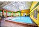 Enclosed, heated pool with a skylight and seating area at 6626 1St N St, St Petersburg, FL 33702