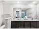 Well-lit bathroom featuring double sinks, dark cabinets and a walk-in shower for a modern feel at 5327 New Friendship Pl, Tampa, FL 33619
