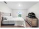 A simple bedroom with a tufted headboard and a large dresser, offering calm space at 5327 New Friendship Pl, Tampa, FL 33619