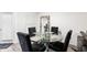 Bright dining room featuring a modern glass-top table, black chairs, and unique decorative mirror at 5327 New Friendship Pl, Tampa, FL 33619
