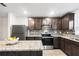 Contemporary kitchen featuring granite countertops, stainless steel appliances, and dark wood cabinetry at 5327 New Friendship Pl, Tampa, FL 33619