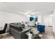 Open living space featuring a large leather couch, modern furnishings, and a view into the dining and kitchen area at 5327 New Friendship Pl, Tampa, FL 33619