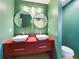 Modern bathroom features dual sinks with red cabinets and round mirrors at 1793 N Fort Harrison Ave, Clearwater, FL 33755