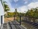 Second story wooden deck with metal railings overlooks lush greenery and the neighborhood at 1793 N Fort Harrison Ave, Clearwater, FL 33755