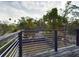 The open-air second story wooden deck features metal railings that overlook the fenced yard at 1793 N Fort Harrison Ave, Clearwater, FL 33755