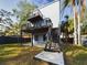 A view of the home's exterior showing the concrete patio, the second-story deck, and yard at 1793 N Fort Harrison Ave, Clearwater, FL 33755